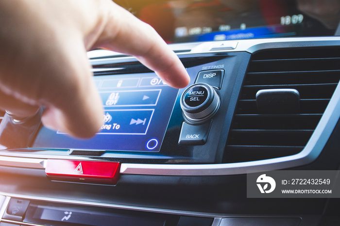 Driver pressing menu/select button of car radio