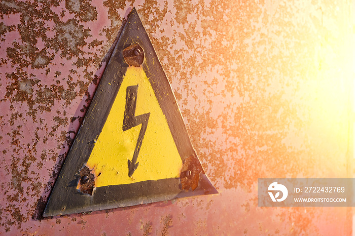 Old, rusty warning about danger and high voltage in form lightning yellow background.