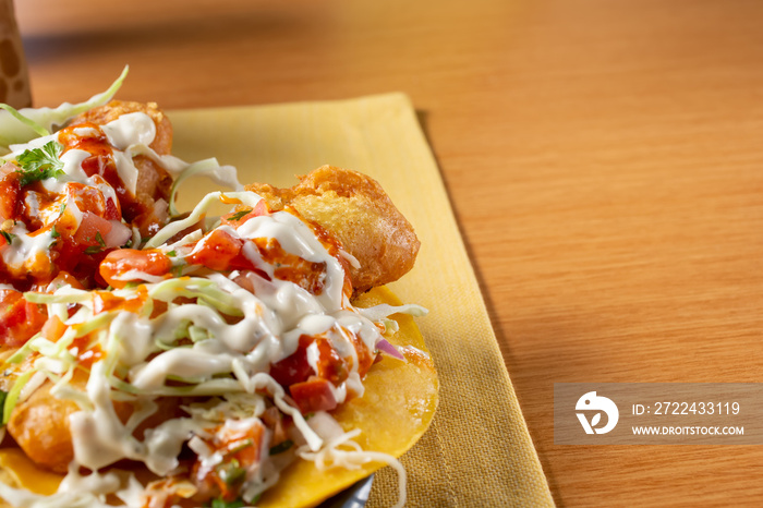 A view of a plate of Baja style fish tacos, cut off on the left side of the frame.