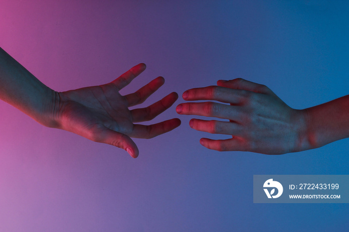 Two hands reach out to each other with a red-blue neon light. Minimalism fashion. Surrealism. Concept art