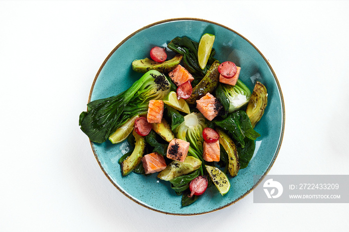 Salmon with artichokes, avocado, close-up, served by the chef with baked salmon and avocado with artichokes in lemon sauce, light background, copy space, top view