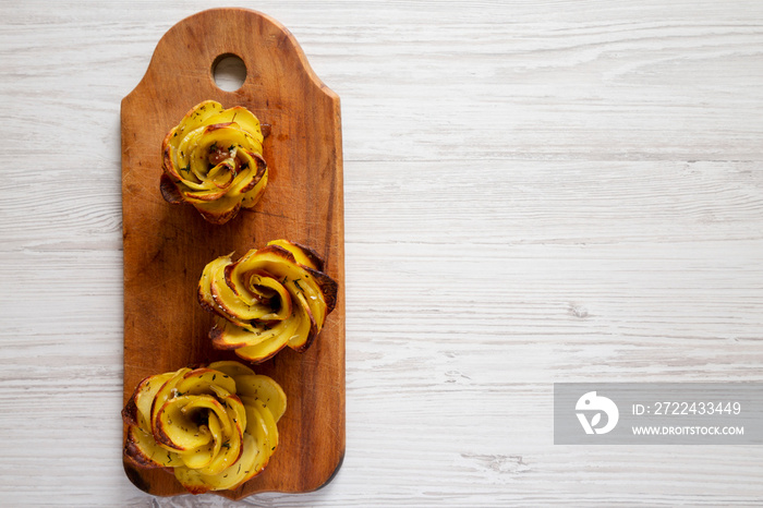 Homemade Potato Roses on a rustic wooden board, top view. Flat lay, overhead, from above. Space for text.