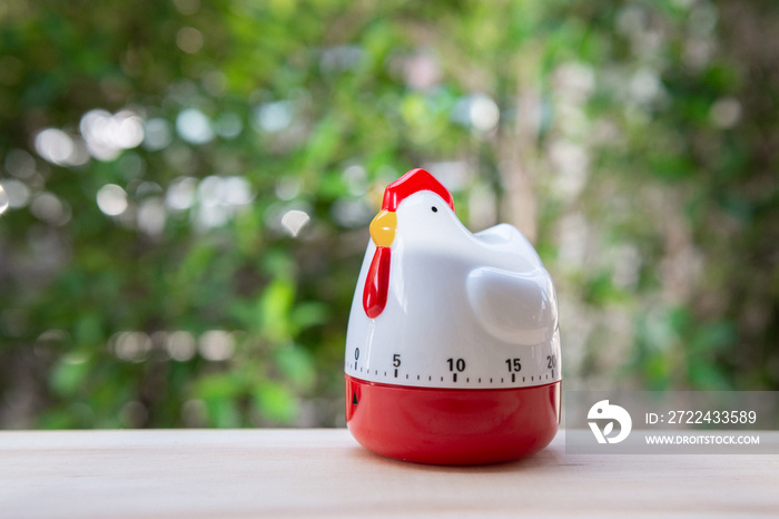 Cooking timer as chicken on the wooden table