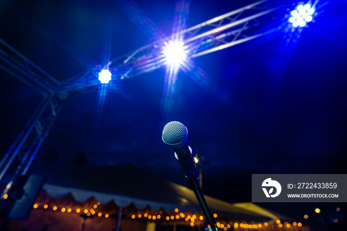 Comedy or Live Music Show at Night Outdoors with Microphone and Blue Lights Nightlife