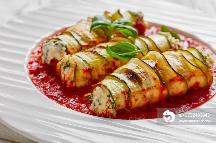 Zucchini rolls baked in tomato sauce on a plate