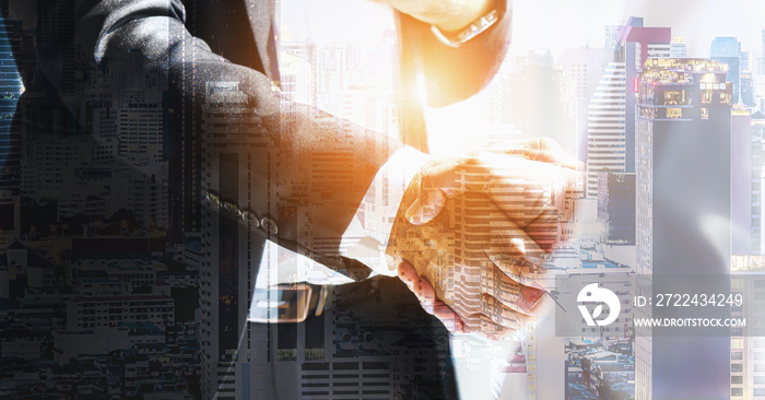 handshaking of businessmen hands overlay with cityscape