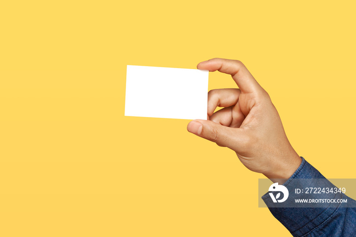 Businessman holding business card on yellow background. Business branding