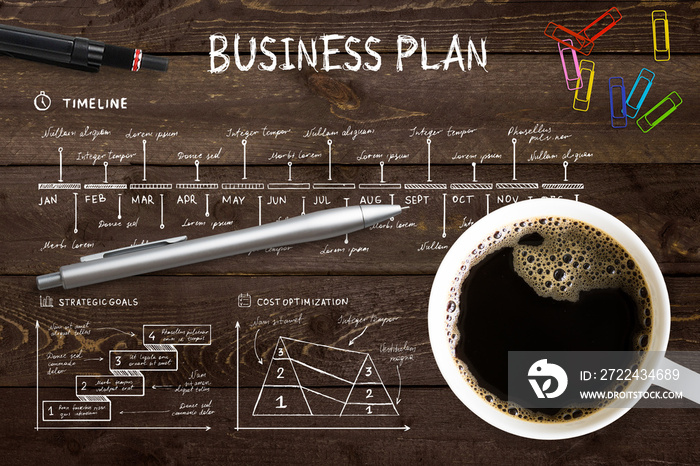 Close-up view from above of a professional desk with a cup full of hot coffee, colored paper clips and a pen on a complex written business plan with copy space