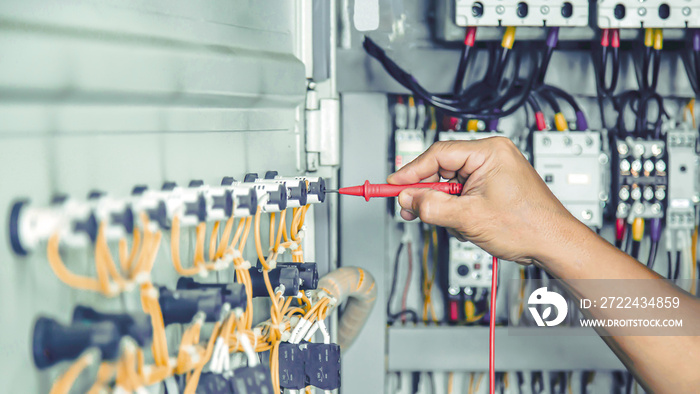 Electrical engineer checking the operation of electrical control cabinet, maintenance concept.