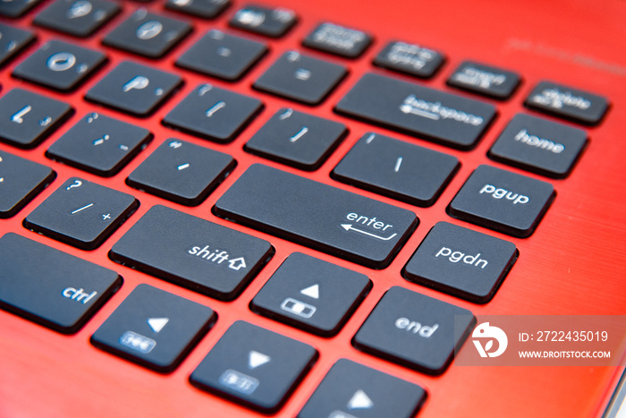 The black keyboard of the red laptop