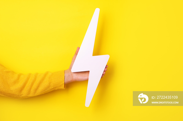 lightning bolt icon in hand  over yellow background
