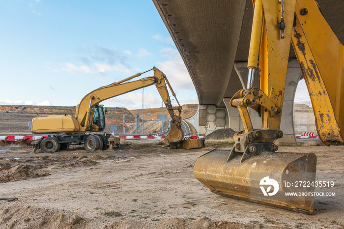 Excavator at the construction works of a bridge in the extension of a highway