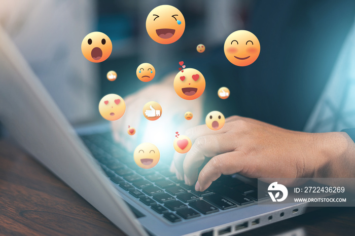 Hands holding and typing to communicate with others through emoji emotion. Online social communication,Social media,emotion, Chat Conversation on laptop. People working using chatting application.