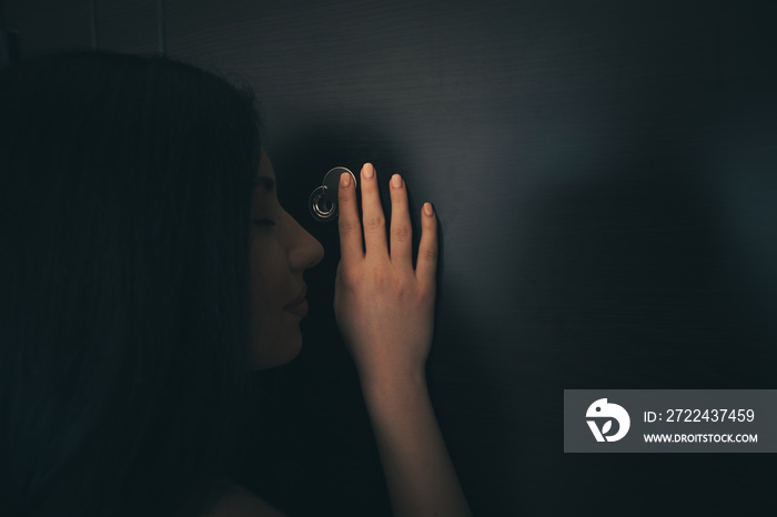 a young girl looks out of the peephole