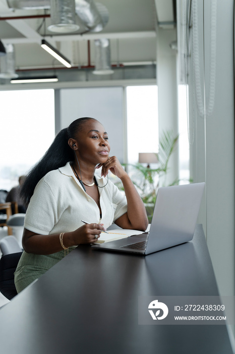 Businesswoman with laptop working in modern office