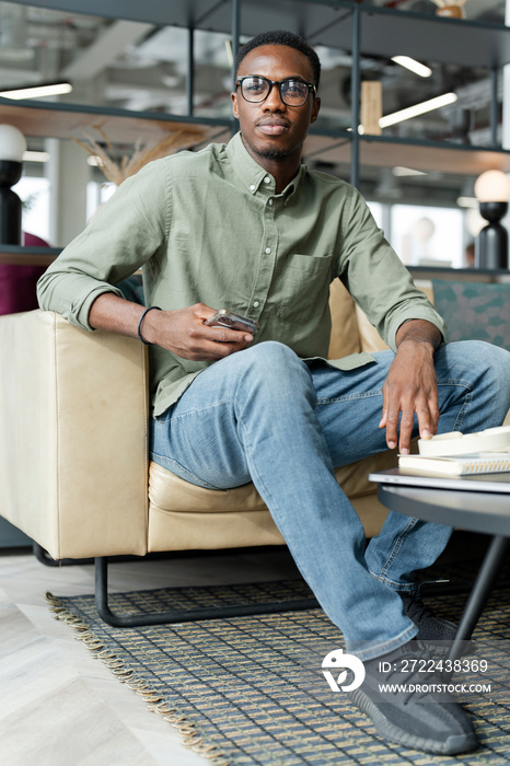 Young man sitting in office lounge