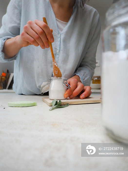 Caucasian woman making homemade vegan deodorant in a glass jar adhering to a zero waste and plastic free lifestyle