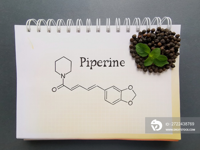 Structural chemical formula of piperine molecule with black pepper grains. Piperine is an amide alkaloid, isolated from Indian medicinal plant Piper nigrum.