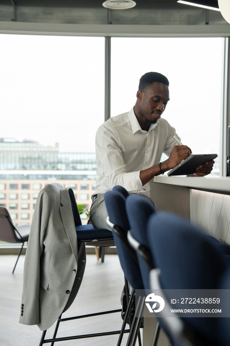 Young businessman using digital tablet in office