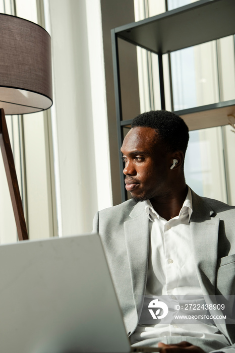 Young businessman using laptop and thinking