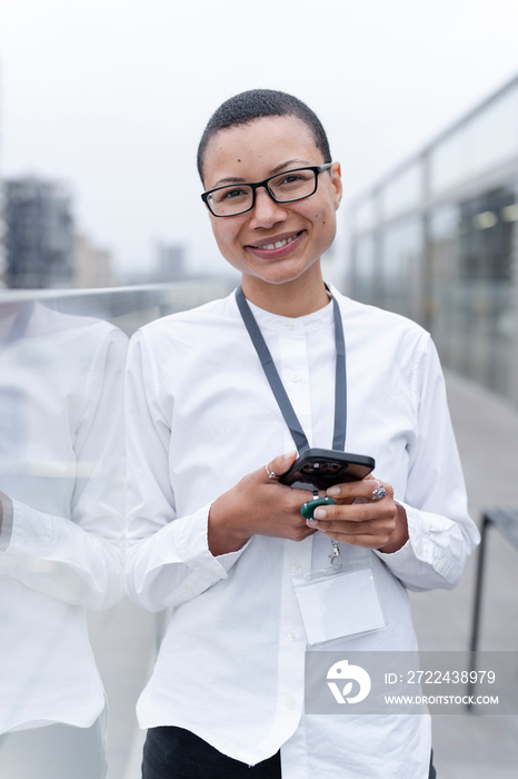 Non binary office worker posing against office buildings