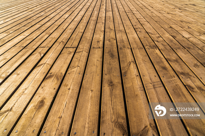 Old weathered wood surface with long boards lined up. Wooden planks on a wall or floor with grain and texture. Dark natural brown tones with contrast.