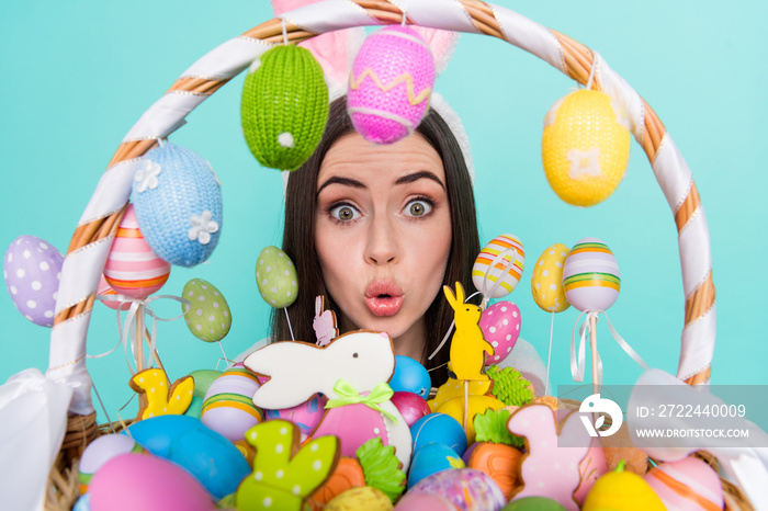 Photo of pretty impressed woman wear striped sweater bunny headband holding colorful eggs isolated turquoise color background