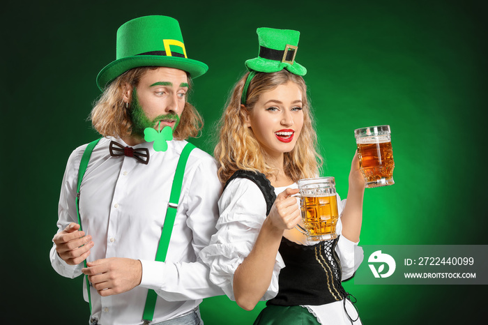 Young couple with beer on color background. St. Patrick’s Day celebration