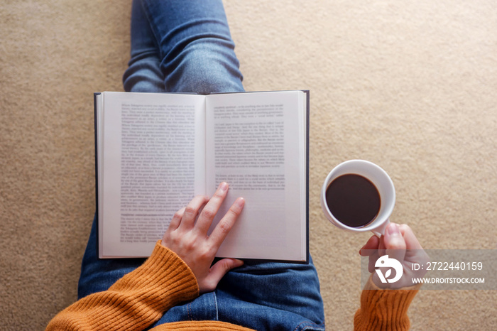 Reading Concept. Soft Focus of  Young Woman Relaxing by Book and Coffee in Cozy House, Sit on the Floor, Top View