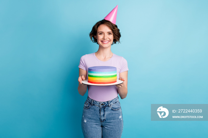 Portrait of positive cheerful girl hold bright cake celebrate birthday anniversary wear cone good look clothes isolated over blue color background