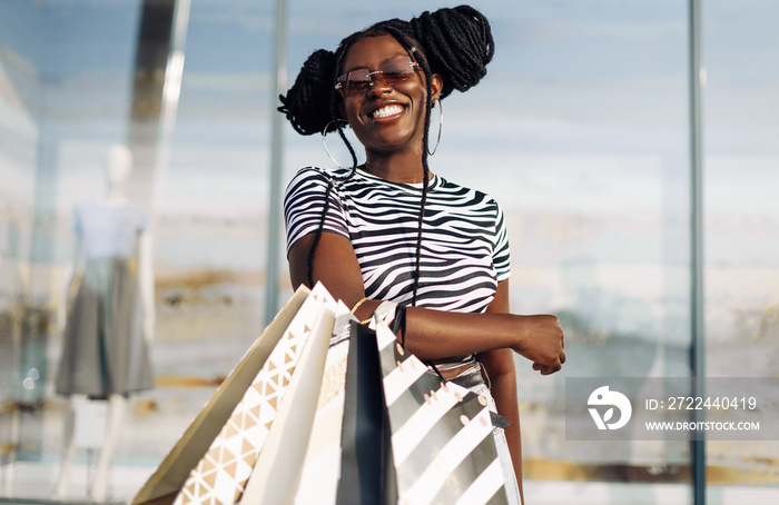 Happy American woman, with shopping bags shopping, fashionable woman enjoying shopping in the city on Black Friday