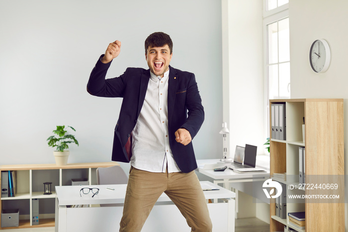 TGIF, Thank God it’s Friday. Happy, cheerful office worker having fun at the end of his workday. Funny, crazy, excited man in a suit celebrating promotion or payday, dancing gangnam style and jumping