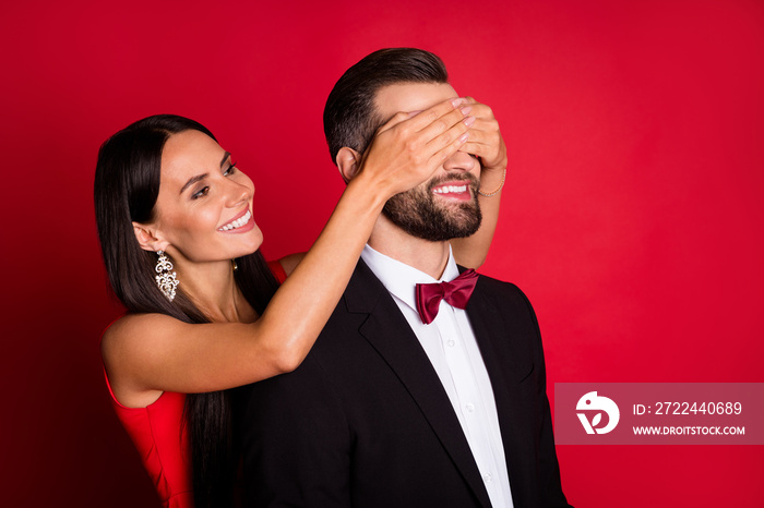 Portrait of attractive woman arms covering eyes handsome man keep intrigue isolated on red color background