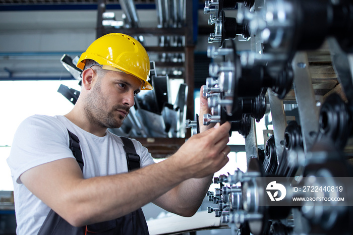 Industrial worker working at production line in factory.