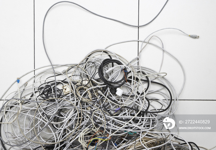 Closeup of tangled computer wires on tiled floor in office