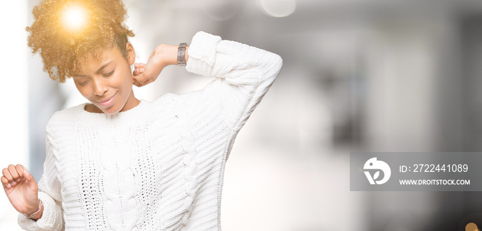 Beautiful young african american woman wearing winter sweater over isolated background stretching back, tired and relaxed, sleepy and yawning for early morning