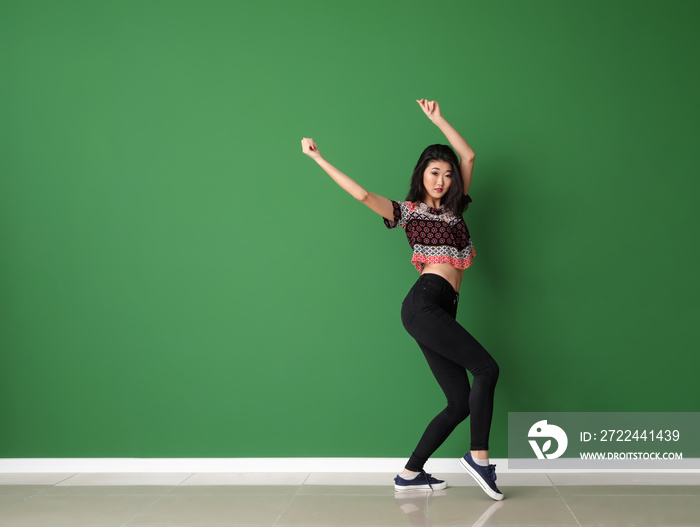 Female Asian dancer near color wall