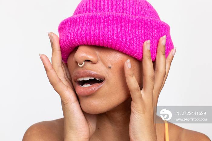 Studio portrait of woman in pink woolen cap