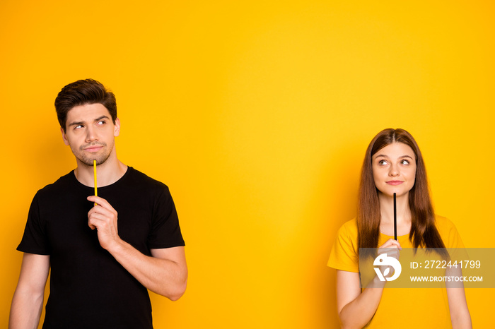 Photo of confident pensive thoughtful couple pondering contemplating empty space above for your advert to be placed isolated vivid yellow color background in black t-shirt