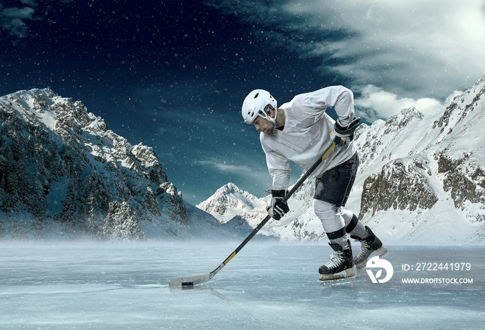 Ice hockey player in action outdoor around mountains