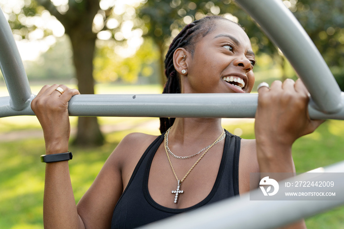 Smiling young woman exercising in outdoor gym