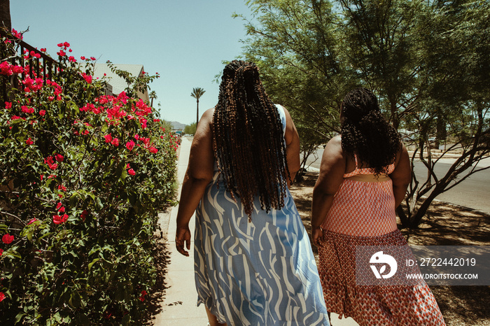 2 African American women walk away down the street