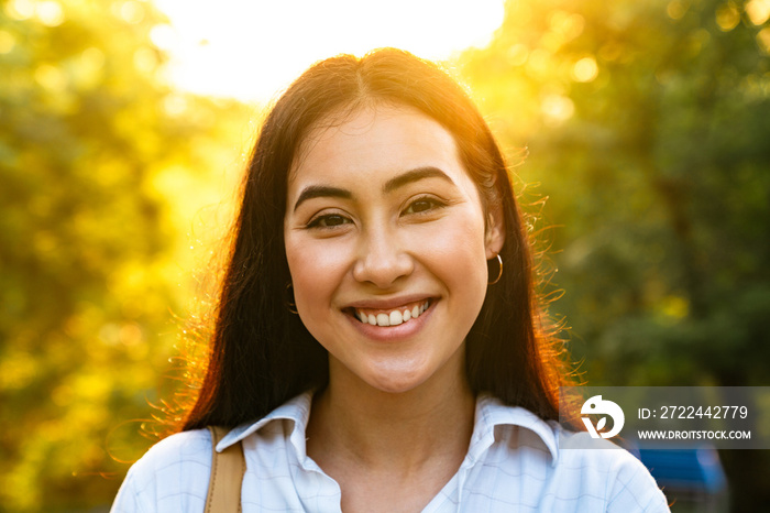 Photo of joyful beautiful asian woman smiling and looking at camera