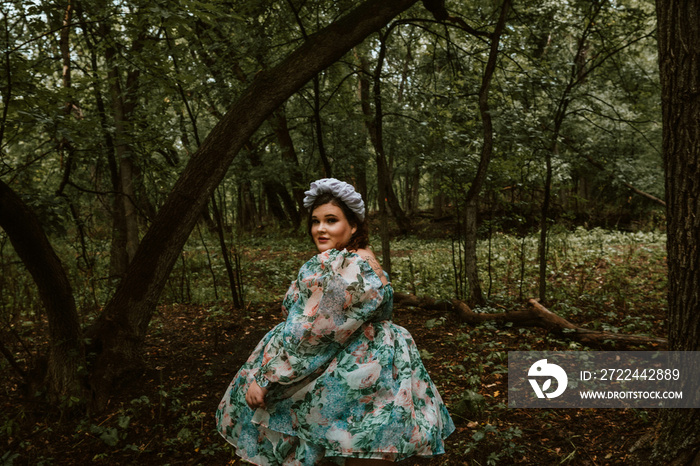 portrait of a plus size woman looking over her shoulder in the forest