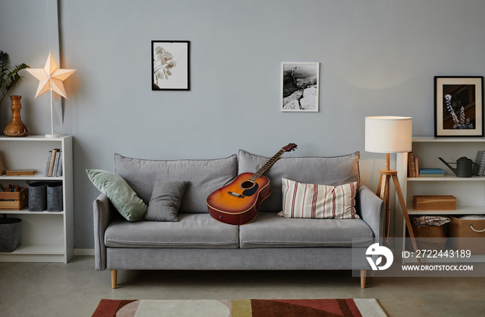 Background image of teenage boys room with acoustic guitar on cozy blue sofa, copy space