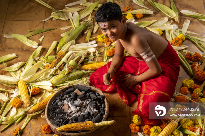 Boy in a red costume roasts carcoal on coals