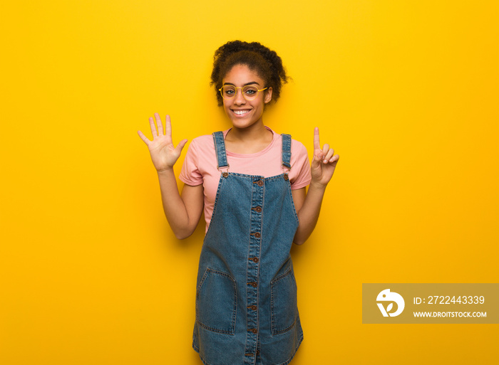 Young black african american girl with blue eyes showing number six