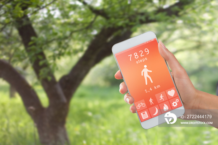 Health monitoring concept - special app on smartphone in a hand outdoors, landscape background