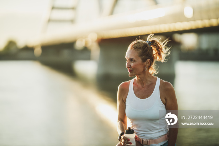 Woman With Water Bottle Before Training Near The River