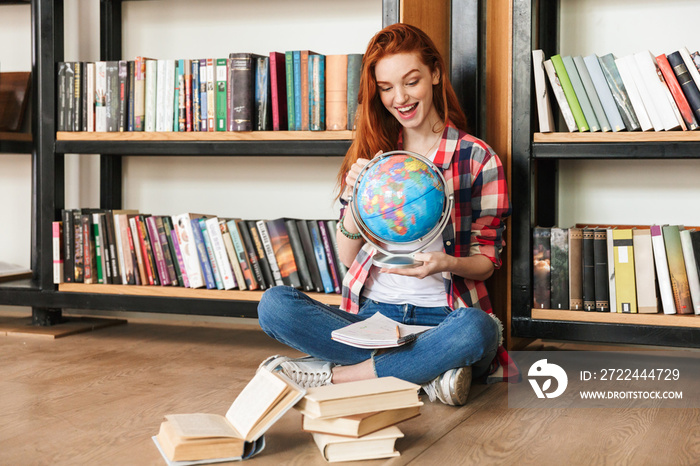 Excited teenage girl holding globe